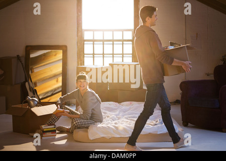 Couple unpacking boxes in attic Banque D'Images