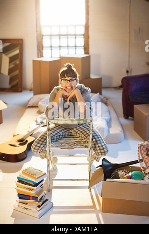 Woman unpacking boxes in attic Banque D'Images