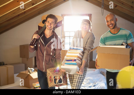 Friends unpacking boxes in attic Banque D'Images