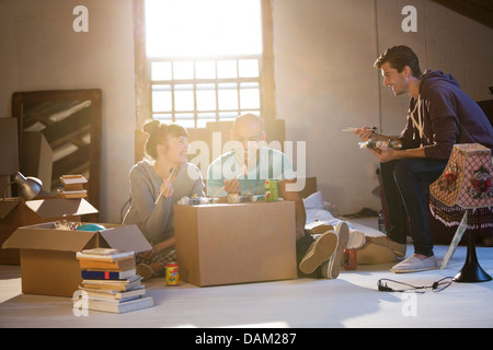 Friends eating sushi in new home Banque D'Images