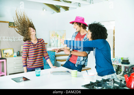 Les amis de jouer ensemble dans la cuisine Banque D'Images