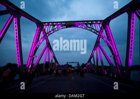 Les visiteurs marchent à travers le pont Glienicke éclairé au cours de la soi-disant "espion" spectacle à Potsdam, Allemagne, 14 mai 2011. Le charmant Filmpark Babelsberg a présenté les cascades, d'artifice et de la musique de film pour créer un décor qui rappelle aux visiteurs de guerre froide-spy films. Pendant la guerre froide, les membres des services secrets ont été transférés entre Berlin Ouest et la RDA dans le célèbre pont. Phot Banque D'Images