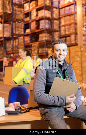 Worker smiling in warehouse Banque D'Images