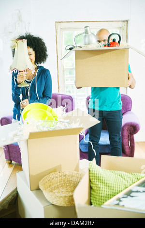 Couple unpacking boxes in new home Banque D'Images