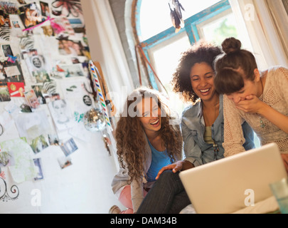 Les femmes utilisant laptop together in bedroom Banque D'Images