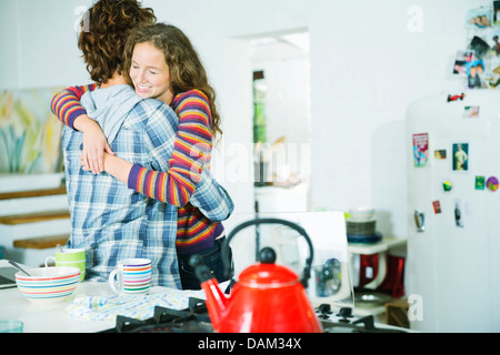 Couple hugging in kitchen Banque D'Images