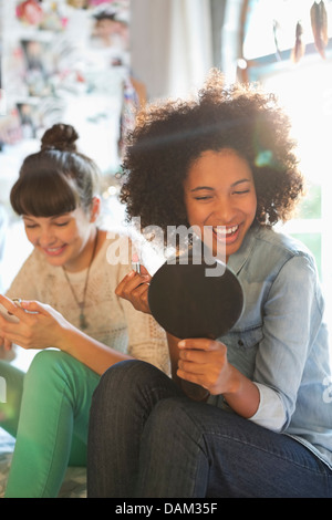 Woman applying makeup in mirror Banque D'Images