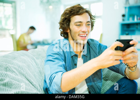 Man using cell phone in fauteuil poire Banque D'Images