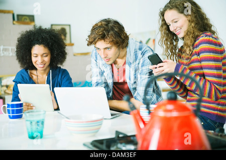 Friends relaxing together in kitchen Banque D'Images