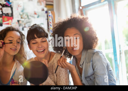 Les femmes appliquant le maquillage dans la chambre Banque D'Images