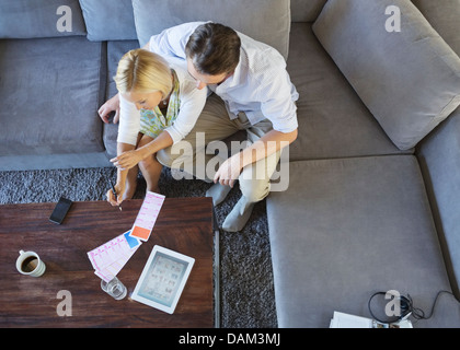 Couple using tablet computer on sofa Banque D'Images