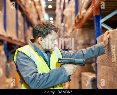 Numérisation travailleur boxes in warehouse Banque D'Images