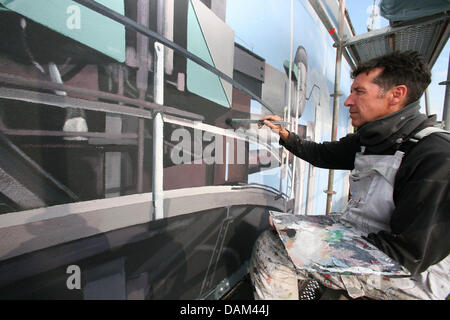 Artiste Hartmut Lindemann de Grünheide, Allemagne peint une fresque géante sur un immeuble de la raffinerie PCK à Schwedt, Allemagne, 14 mai 2011. Sur cinq domaines dans un des murs d'environ 1000 mètres carrés, la plus longue en Allemagne murale est peinte et prendra fin le 17 mai. Photo : Nestor Bachmann Banque D'Images