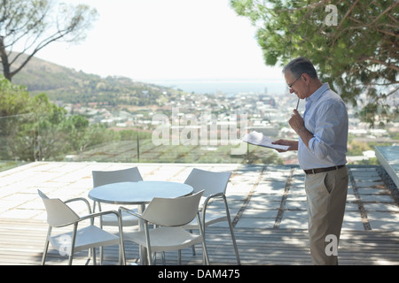 Older Man using tablet computer outdoors Banque D'Images