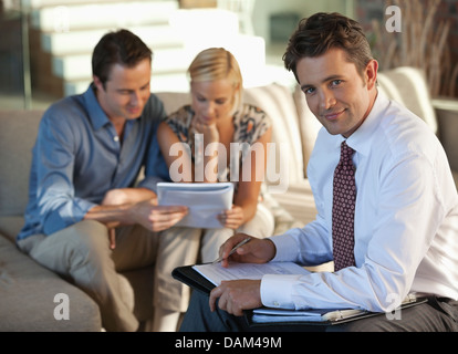 Conseiller financier avec couple on sofa Banque D'Images