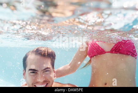 Couple playing in swimming pool Banque D'Images