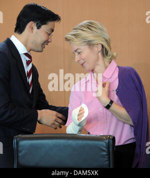 La ministre du Travail allemande, Ursula von der Leyen, ministre allemand de l'économie parle et vice-chancelier Philipp Roesler et porte une attelle sur son bras droit avant une réunion du cabinet à la chancellerie à Berlin, Allemagne, 25 mai 2011. La réunion du cabinet souhaite discuter de la réforme de la politique du marché de la promotion d'instruments présentés par von der Leyen. Photo : Rainer Jensen Banque D'Images