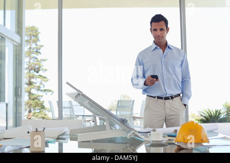 Businessman using cell phone in office Banque D'Images