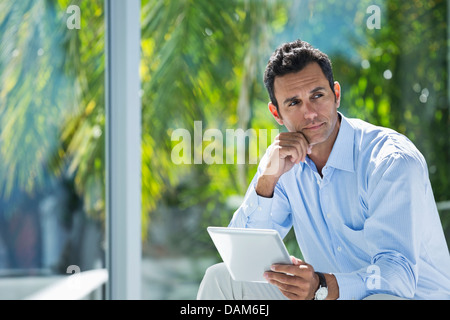 Businessman using tablet computer in office Banque D'Images