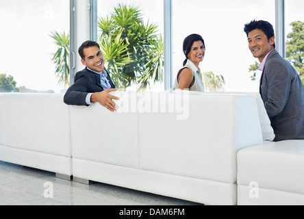 Business people smiling on sofa Banque D'Images