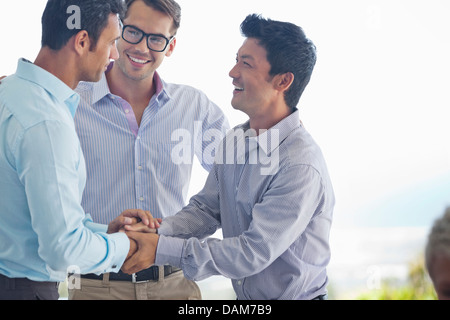 Businessmen shaking hands in office Banque D'Images