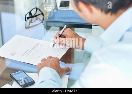 Businessman making notes at desk Banque D'Images