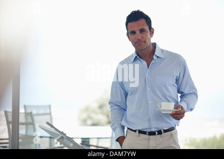 Businessman having cup of coffee in office Banque D'Images