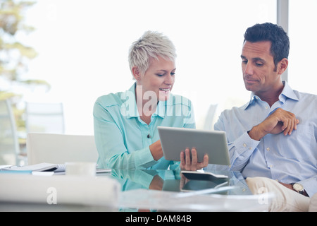 Business people using tablet computer on sofa Banque D'Images