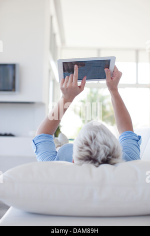 Woman using tablet computer on sofa Banque D'Images