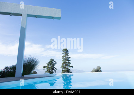 Arbres et douche donnant sur piscine à débordement Banque D'Images