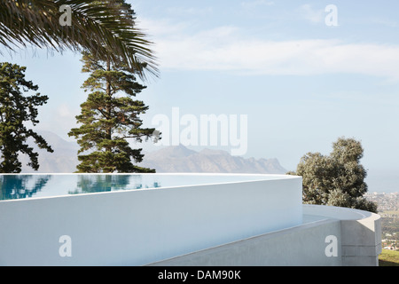 Piscine à débordement avec vue sur les arbres et colline Banque D'Images