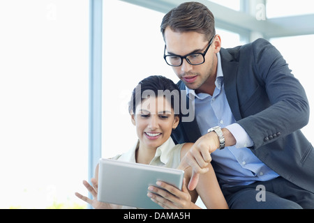 Business people using tablet computer on sofa Banque D'Images