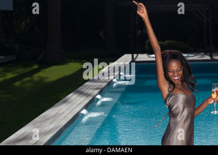 Woman dancing by swimming pool at party Banque D'Images