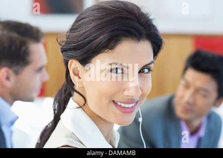 Businesswoman listening to headphones in office Banque D'Images