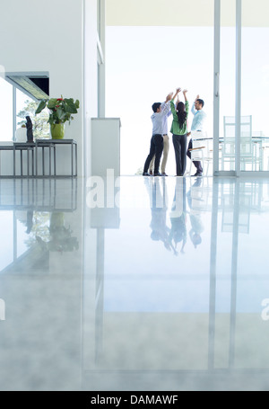 Les gens d'affaires cheering in office Banque D'Images