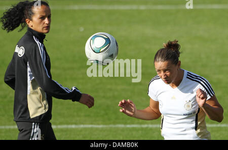 Joueur de football nationale allemande Fatmire Bajramaj (L) observe son coéquipier Inka Grings effectuant une coupe pendant une session de formation de l'équipe nationale en Osnabrueck, Allemagne, 02 juin 2011. L'équipe fait face à l'Italie pour un match de football international le 03 juin 2011. Photo : Friso Gentsch Banque D'Images