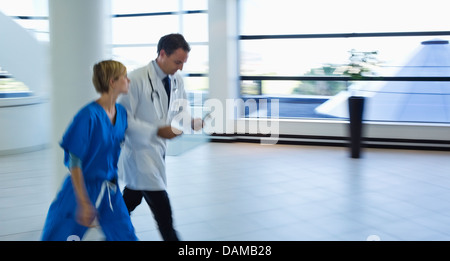 Doctor and nurse talking in hospital hallway Banque D'Images