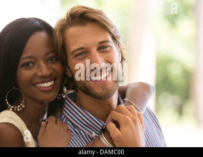 Smiling couple hugging indoors Banque D'Images