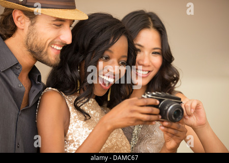 Des amis à l'aide de camera at party Banque D'Images