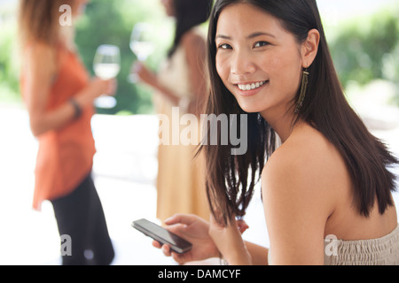 Smiling woman using cell phone Banque D'Images