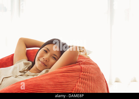 Smiling woman relaxing in fauteuil poire Banque D'Images