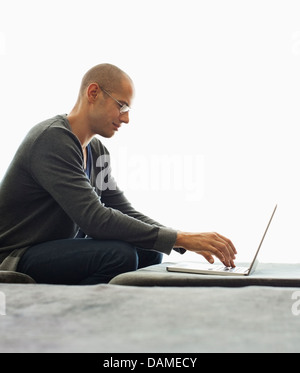 Man using tablet computer in living room Banque D'Images