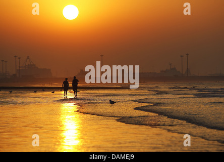 Deux promeneurs marchant sur la plage le soir, Belgique Banque D'Images