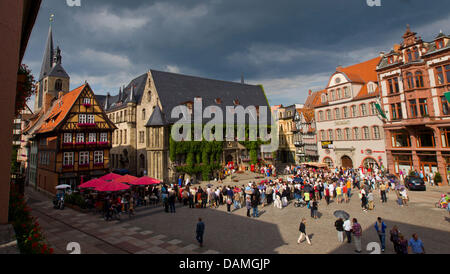 Touristes se mêlent en face de l'hôtel de ville sur la place du marché à Quedlingburg, Allemagne, 12 juin 2011. La vieille ville de Quedlingburg accueille plus de 1.200 bâtiments à pans de bois et a été un des sites du patrimoine culturel mondial par l'UNESCO depuis 1994.Photo : Jens Wolf Banque D'Images