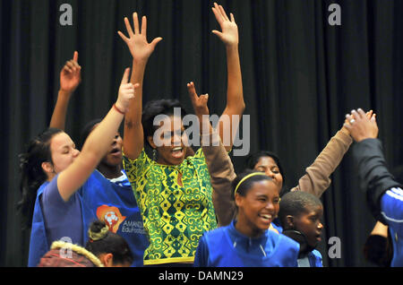 Première Dame Michelle Obama est raising arms quand elle a rencontré les enfants d'un projet social à Greenpoint Stadium le Jeudi, 23. Juin 2011. Elle a rencontré l'ancien archevêque Desmond Tutu à Cape Town. L'épouse de président des États-Unis Barack Obama est sur une nation deux cinq jours de visites d'Afrique du Sud et le Botswana. Ralf Hirschberger dpa Banque D'Images