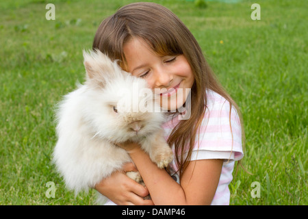 Lapin nain (Oryctolagus cuniculus f. domestica), sept ans, fille avec lapin nain Banque D'Images