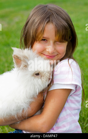 Lapin nain (Oryctolagus cuniculus f. domestica), sept ans, fille avec lapin nain Banque D'Images