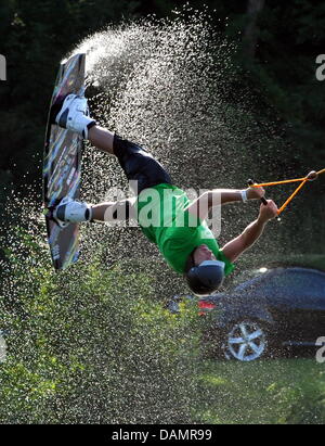 Patrick Wakeboarder Haberstroh saute au lac Tuni à Freiburg, Allemagne, 28 juin 2011. Un tour avec l'eau-ski ascenseur à travers l'étang de la carrière de refroidissement est un plaisir dans la chaleur de l'été. L'ascenseur tire les athlètes de wakeboard sur le lac. Certains meilleurs planchistes aussi sauter par-dessus les obstacles. Photo : Rolf Haid Banque D'Images