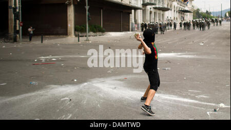 Des manifestants et la police clash en émeutes violentes avec un seul manifestant jetant une pierre à polaice officiers dans la rue en face de l'édifice du parlement à Athènes, Grèce, le 29 juin 2011. Le parlement grec à Athènes a décidé ce mercredi 29 juin 2011 sur le plan d'austérité sévère qui vise à sauver la Grèce de la faillite. Photo : ARNO BURGI Banque D'Images