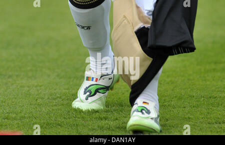 German women's national soccer player Celia Okoyino Da Mbabi porte des chaussures décorées avec des camerounais et le drapeau français sur la droite et le drapeau allemand sur la gauche pendant une séance d'essai au Sportpark Stadium à Meerbusch, Allemagne, 02 juillet 2011. Comme elles représentent les couleurs de son héritage, son père venant du Cameroun et sa mère d'être Français. Photo : Carmen Jaspers Banque D'Images